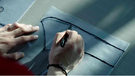 Hands marking a seat-cover pattern during development