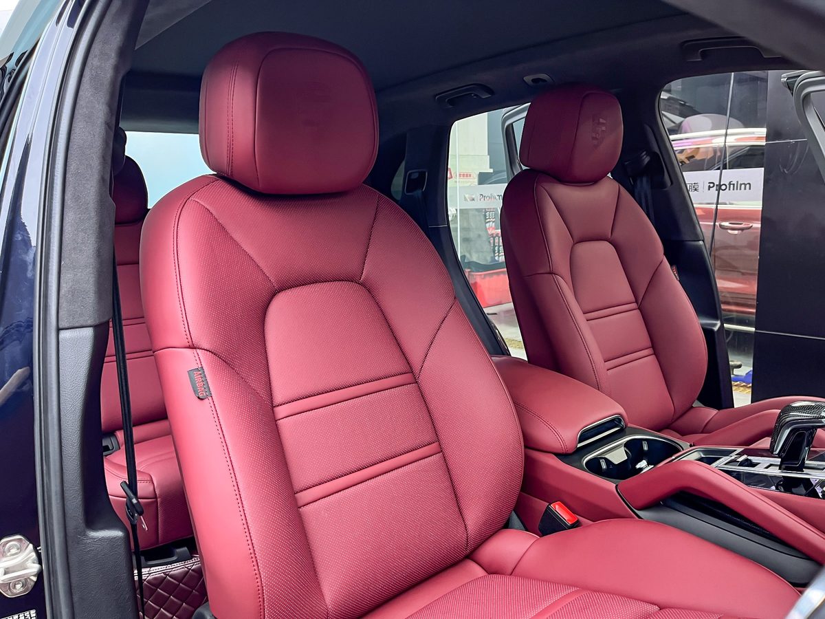 Porsche Cayenne front seats with Burgundy custom-fit seat covers showing contoured fit, perforated center panels and factory seat details